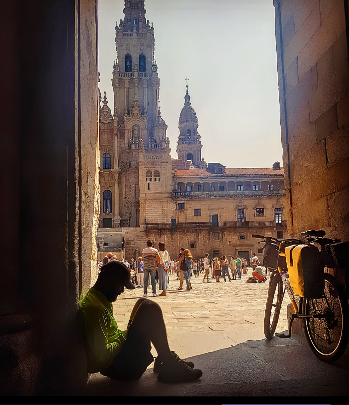 Peregrino con su bicicleta y de fondo la Catedral