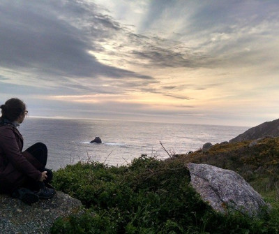 Peregrina viendo el atardecer en el Camino a Fisterra